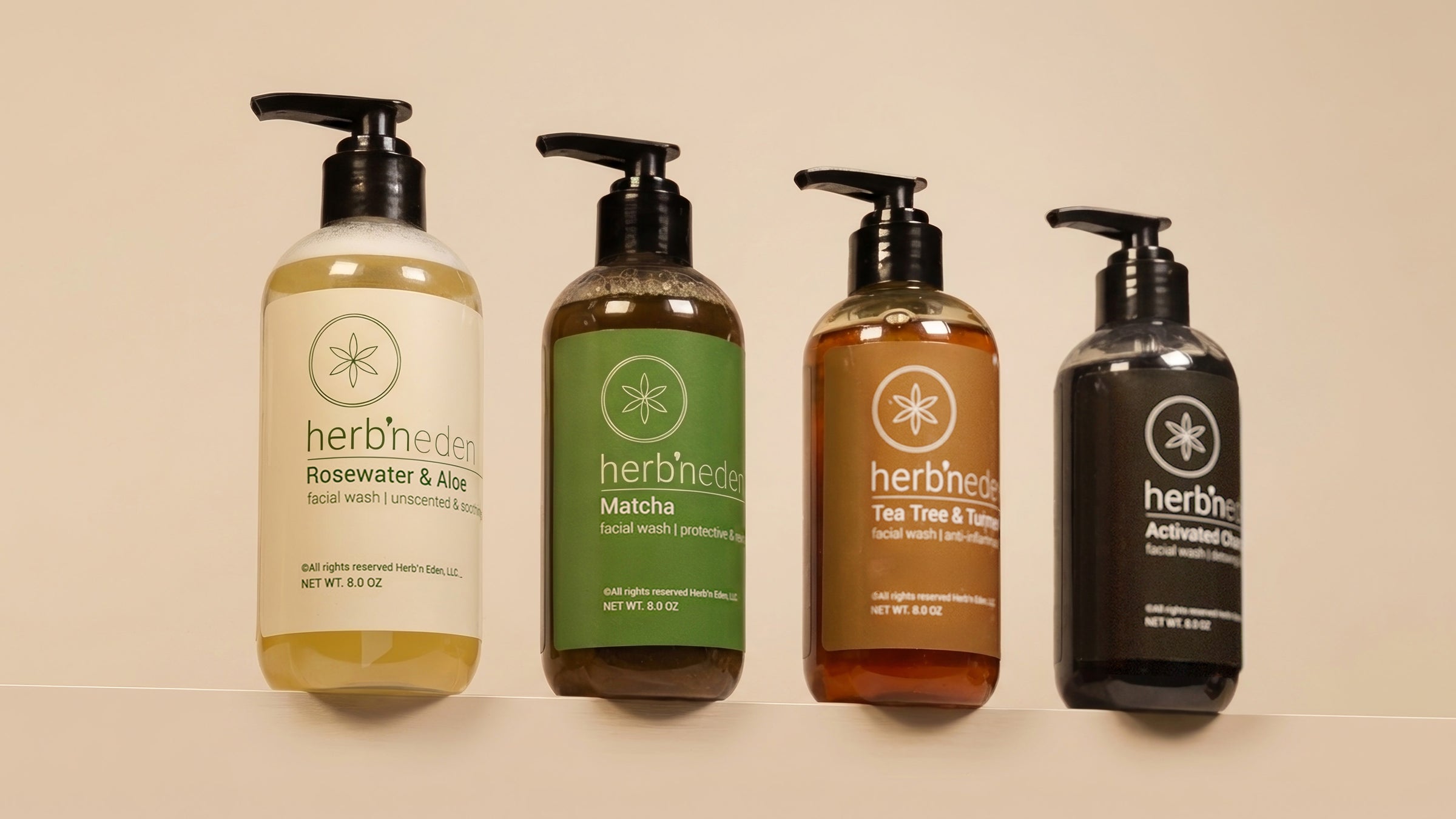 Four Herb’n Eden facial wash bottles (Rosewater & Aloe, Matcha, Tea Tree & Turmeric, and Activated Charcoal) arranged in a row on a neutral background.